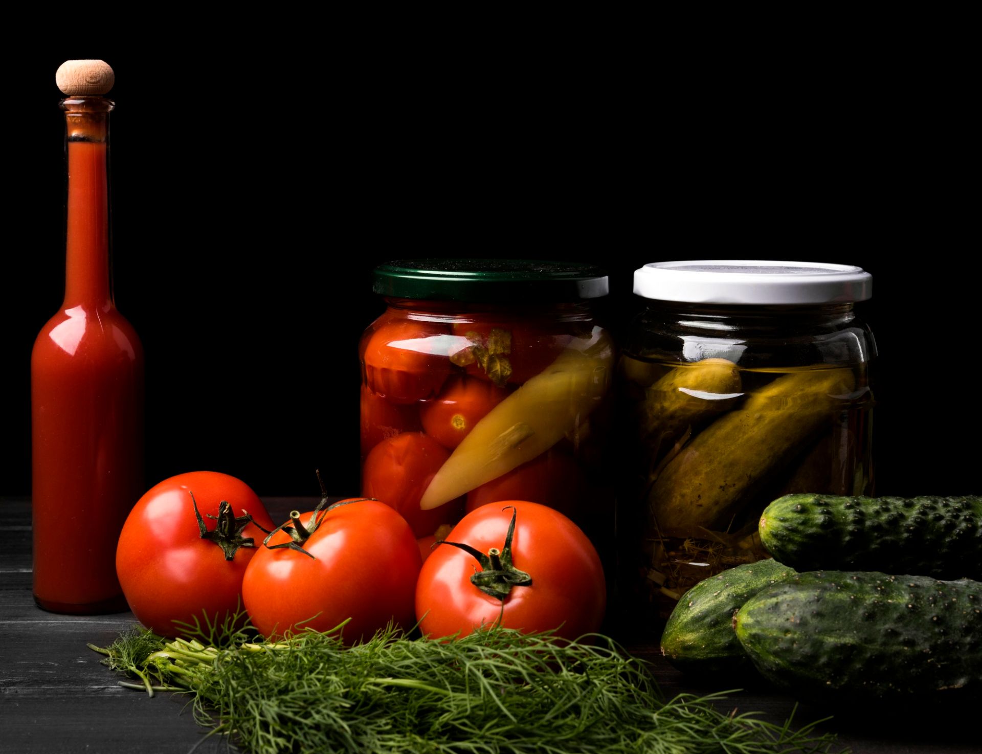 Fresh salad produce and pickled jars of tomatoes and cumcuber